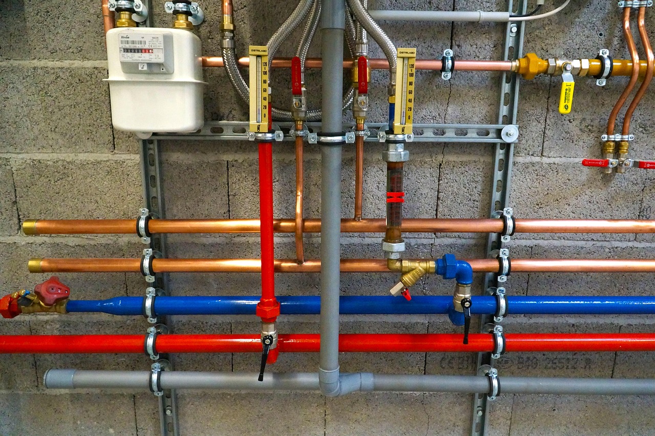 Color-coded hot and cold plumbing pipes on a wall