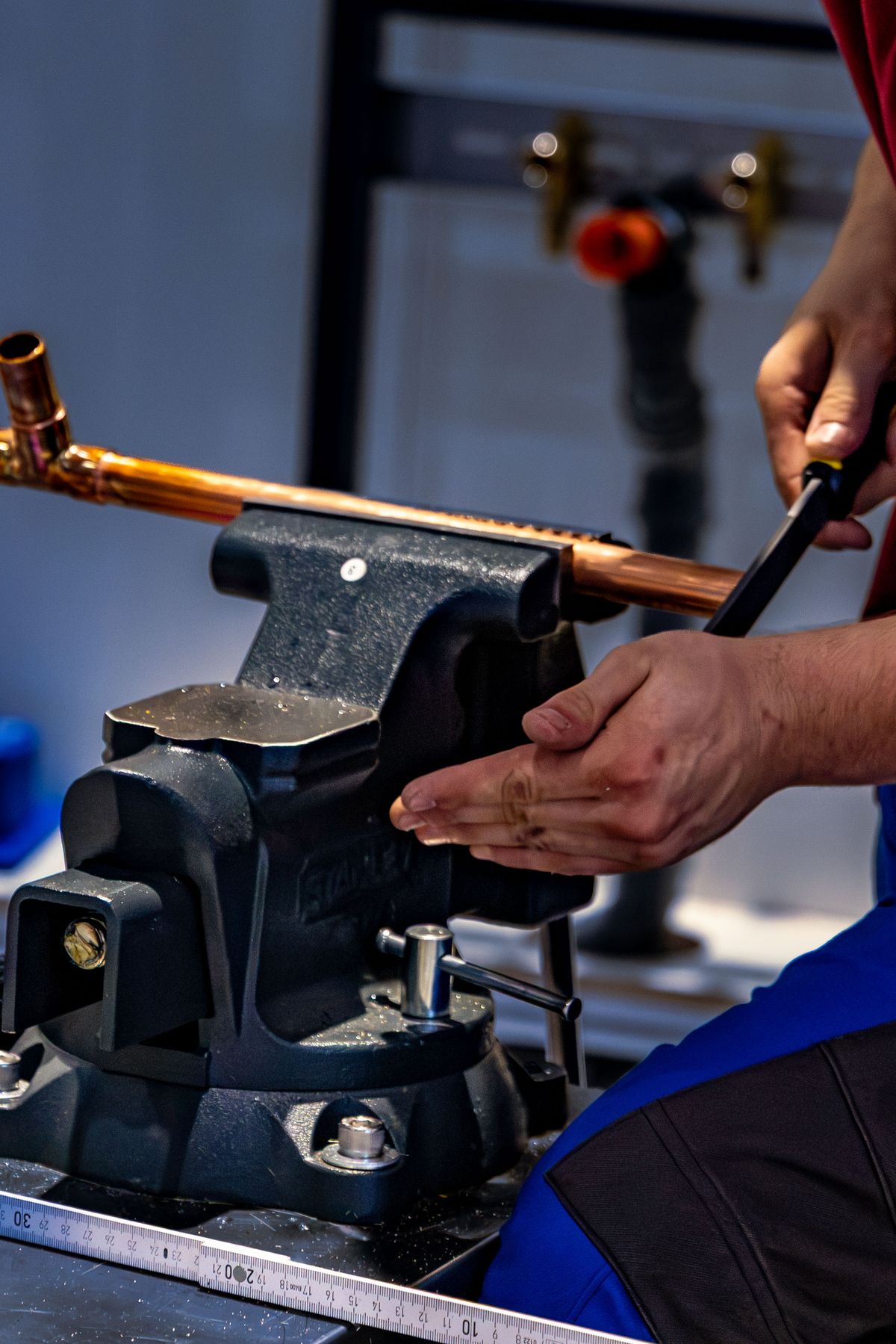 Plumber bending a copper pipe with a pipe bender