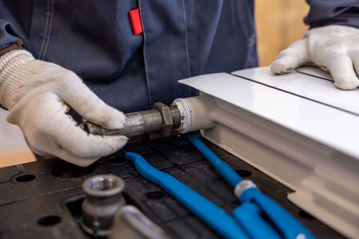 Plumber installing a pipe connection with a wrench